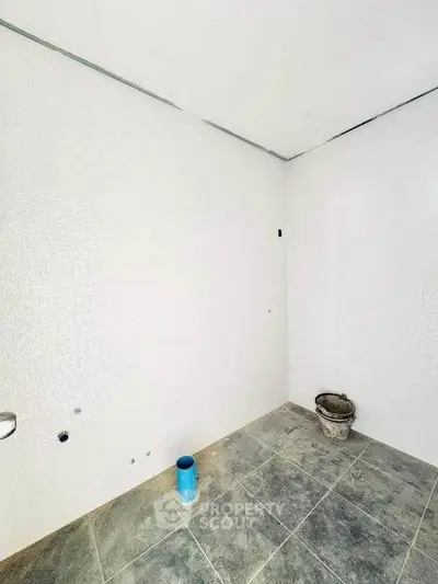 Unfinished bathroom with tiled floor and white walls, ready for fixtures.