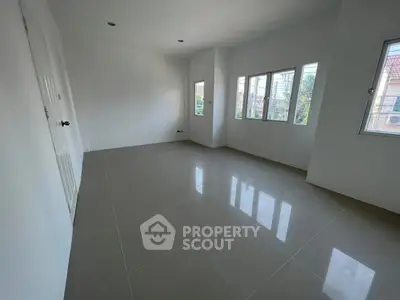 Spacious empty room with large windows and glossy tiled floor, perfect for customization.