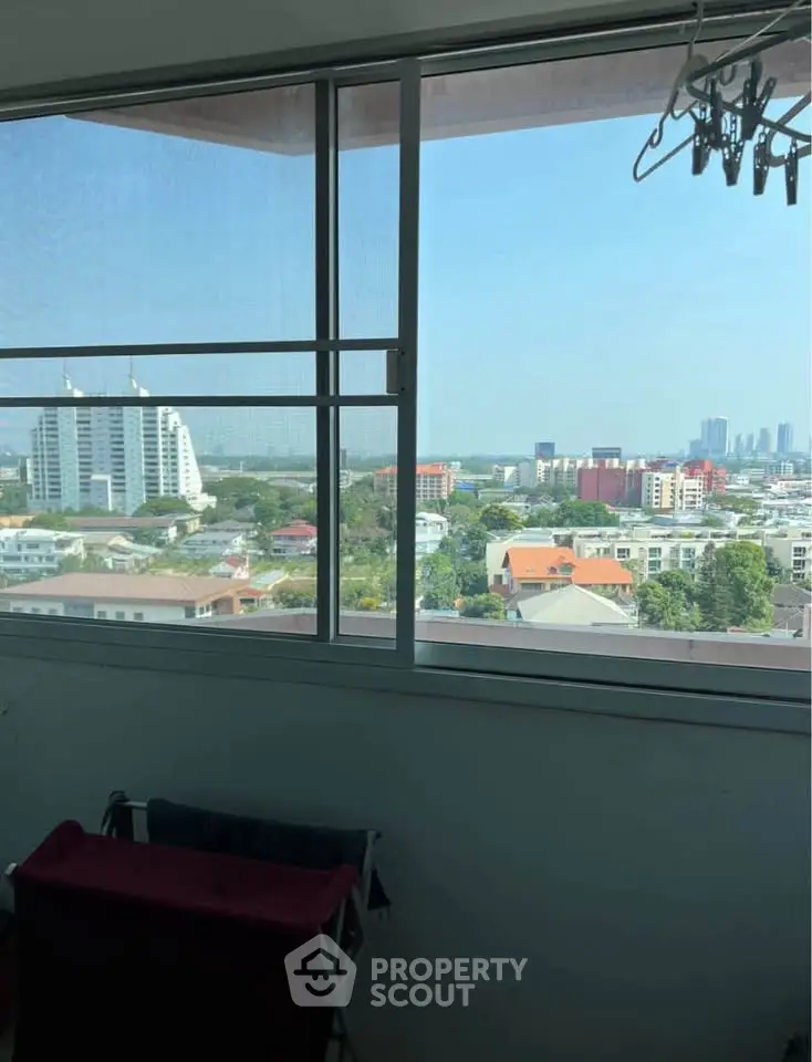 Stunning cityscape view from high-rise apartment window, showcasing urban skyline and residential buildings.