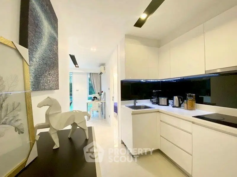 Modern kitchen with sleek white cabinets and stylish decor in a contemporary apartment.