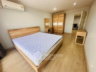 Spacious bedroom with wooden furniture and modern decor in a stylish apartment.