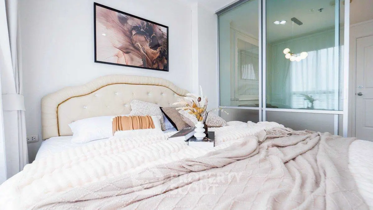Cozy bedroom with elegant decor and soft lighting, featuring a plush bed and stylish artwork.