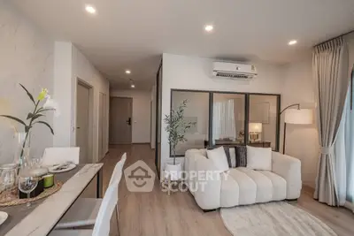 Modern living room with cozy sofa and elegant dining area in open layout apartment.