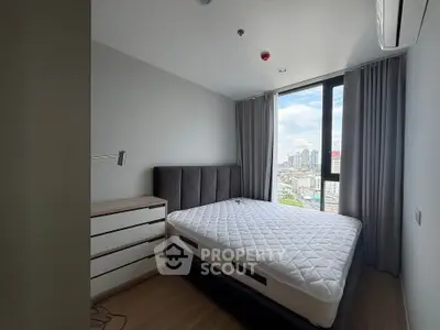 Modern bedroom with city view, featuring a comfortable bed and sleek furniture, perfect for urban living.