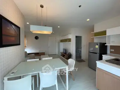 Modern open-plan living room and kitchen with sleek furniture and natural light.