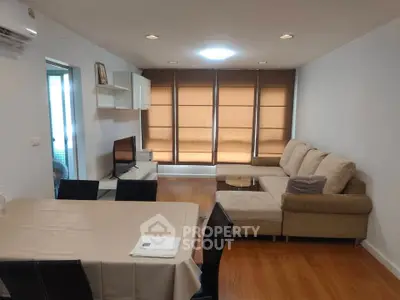 Spacious living room with modern furniture and large windows in a stylish apartment.