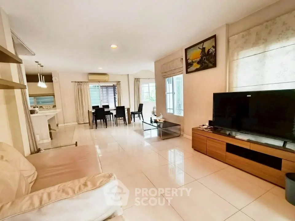 Spacious living room with modern decor and large TV, perfect for family gatherings.