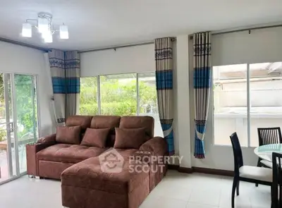 Spacious living room with large windows and modern brown sectional sofa
