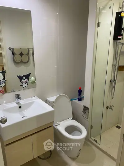 Modern bathroom with sleek fixtures and glass shower enclosure in a contemporary apartment.