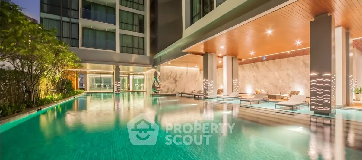 Luxurious modern pool area with elegant lighting and stylish lounge chairs in a high-end residential complex.