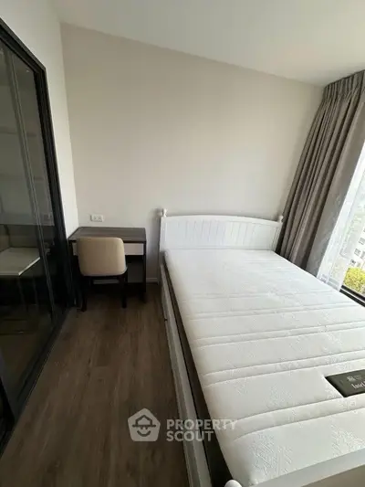 Modern bedroom with large window and minimalist decor, featuring a comfortable bed and study desk.
