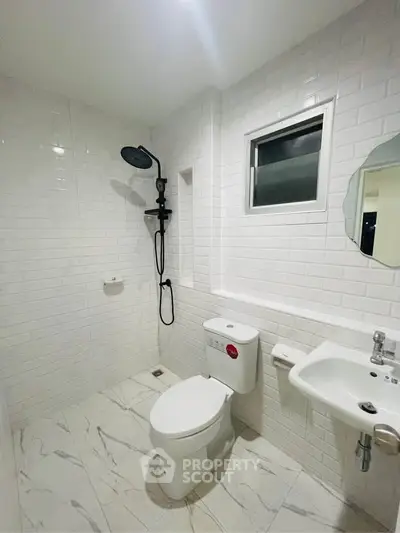 Modern white bathroom with sleek fixtures and subway tile design.