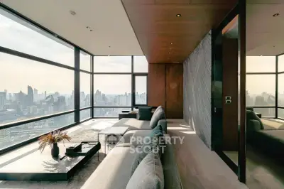 Luxurious living room with panoramic city views and modern furnishings in a high-rise apartment.