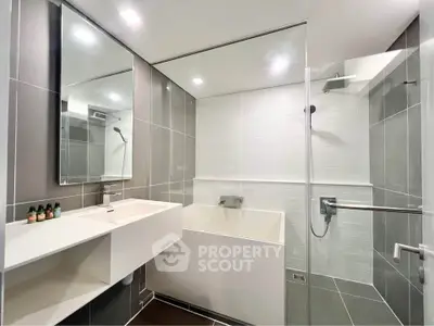 Modern bathroom with sleek design, featuring a spacious shower and elegant fixtures.