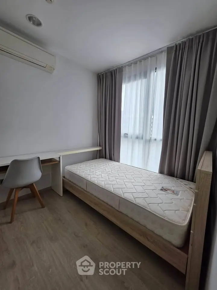 Modern minimalist bedroom with single bed, study desk, and large window with curtains.