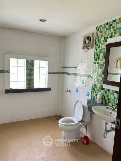 Spacious bathroom with modern fixtures and large window for natural light.