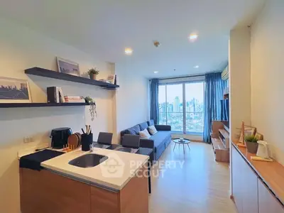 Modern open-plan living room with city view, featuring sleek kitchen and cozy seating area.