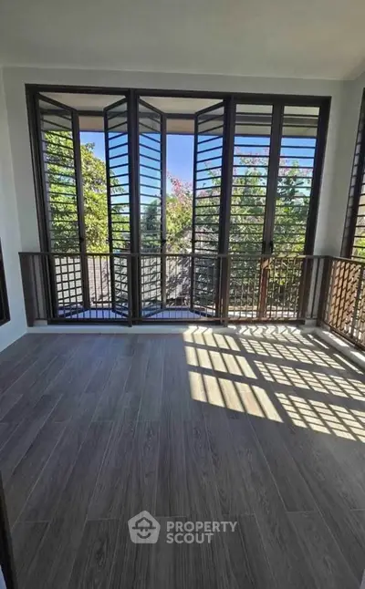 Spacious balcony with large windows offering a scenic view, perfect for relaxation and enjoying natural light.