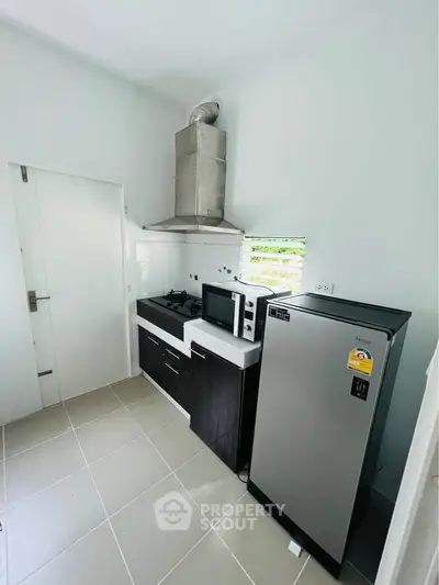Modern kitchen with sleek appliances and gas stove in compact layout