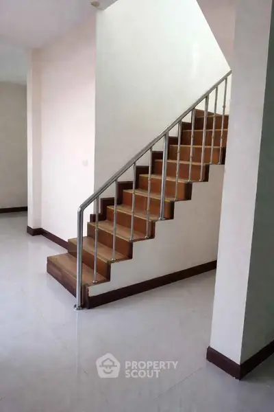 Modern staircase with sleek metal railing in a spacious interior