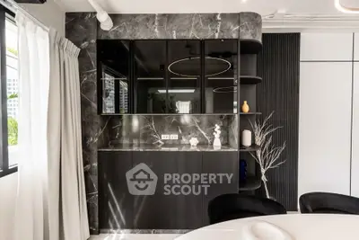 Modern living room with sleek black cabinetry and marble accents