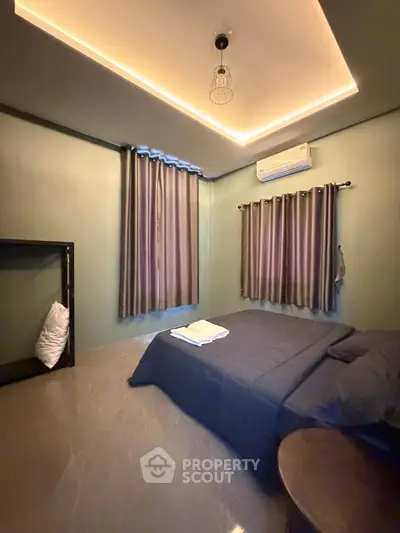 Cozy bedroom with modern lighting and air conditioning, featuring elegant curtains and a comfortable bed.