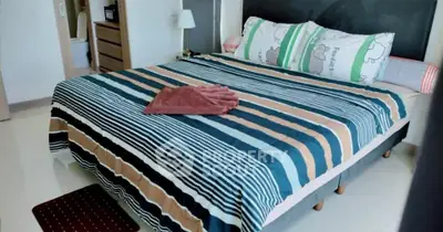 Spacious bedroom with stylish striped bedding and modern decor