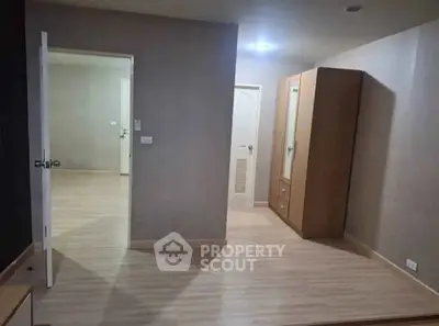 Spacious interior with wooden flooring and modern wardrobe in a well-lit room.
