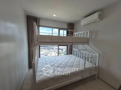 Modern bedroom with bunk bed and city view, featuring air conditioning and large window for natural light.