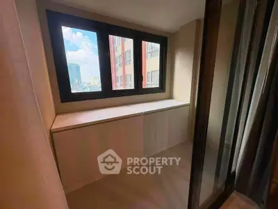Bright corner unit with large windows offering city views, perfect for a cozy reading nook or storage space.