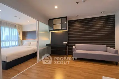 Modern studio apartment with cozy bedroom and stylish living area, featuring wood flooring and sleek design.