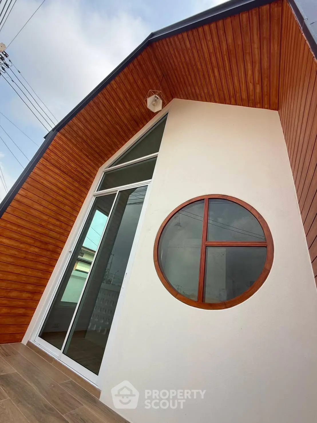 Modern architectural exterior with unique circular window and wooden accents