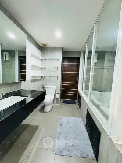 Modern bathroom with sleek design, featuring a large mirror and elegant fixtures.