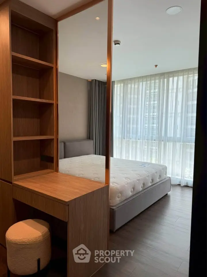 Modern bedroom with large window and stylish wooden furniture
