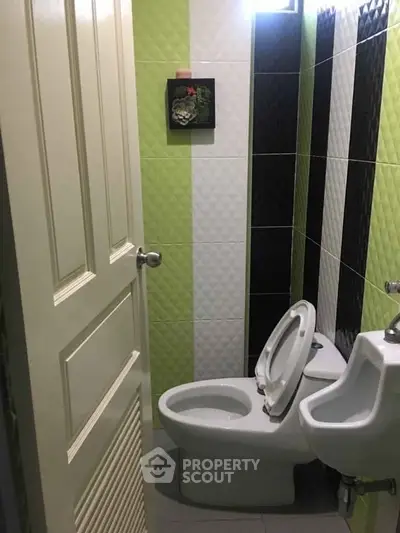 Compact bathroom with modern green and black tile design