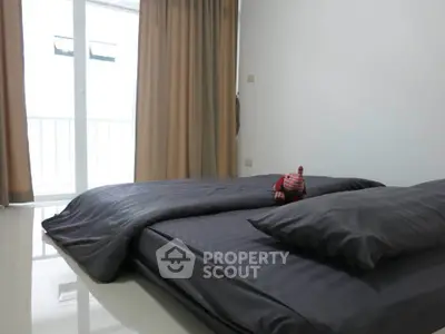 Modern bedroom with minimalist decor and balcony access