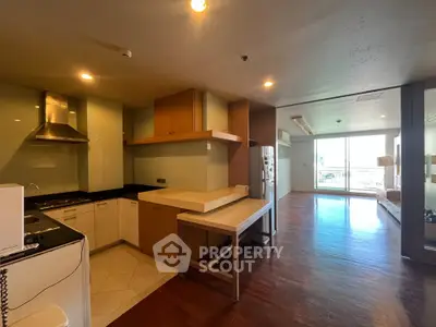 Spacious open-layout kitchen and living area with modern appliances and large windows offering natural light.