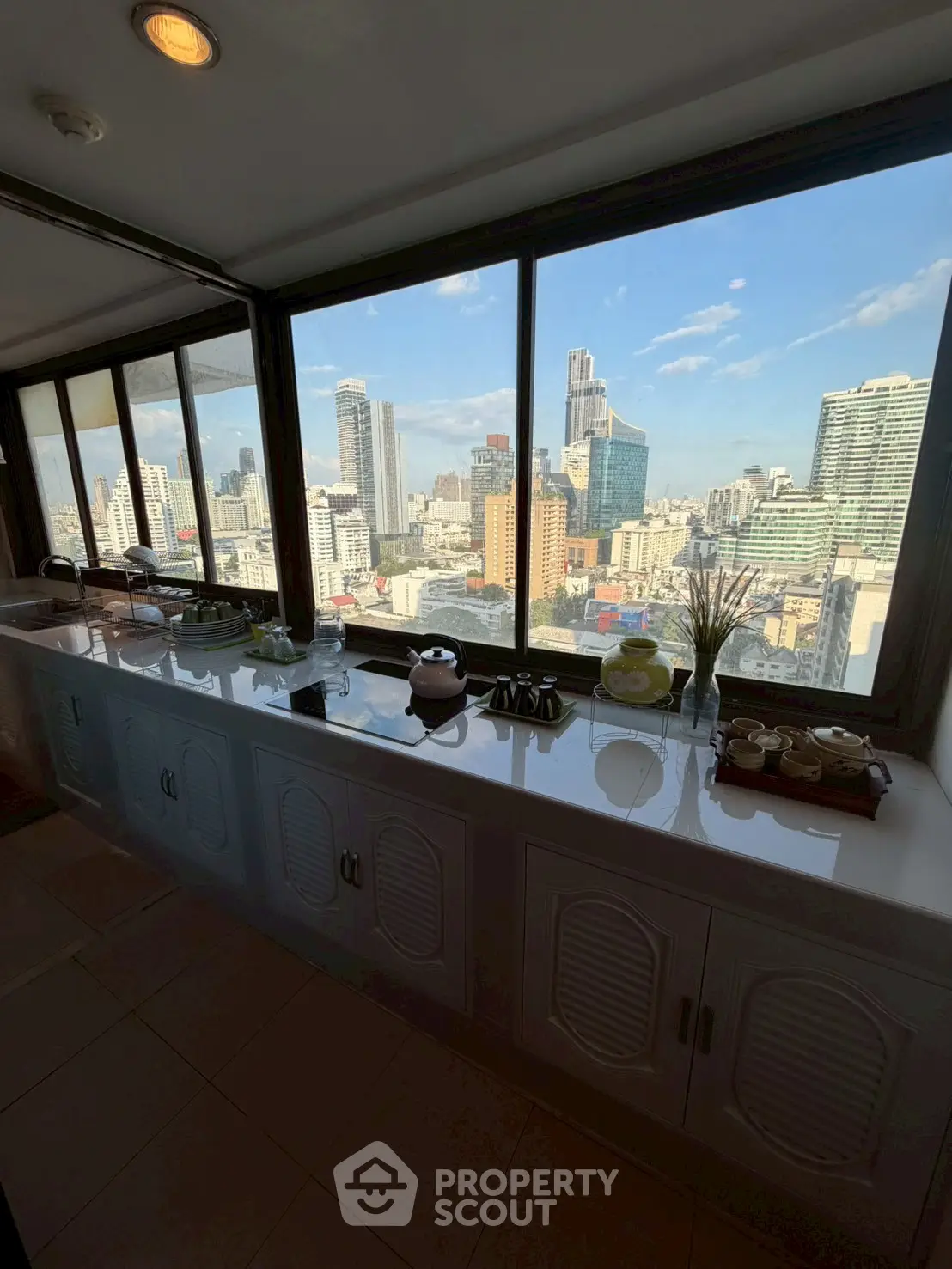 Stunning cityscape view from a high-rise apartment window with modern interior decor.