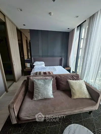 Luxurious bedroom with modern decor and large windows offering natural light and city views.