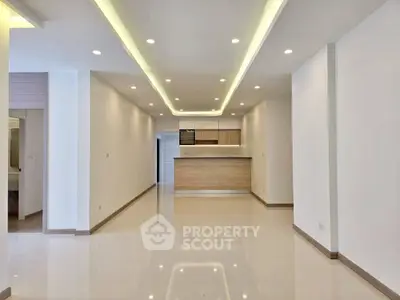 Spacious modern living room with open kitchen and sleek lighting