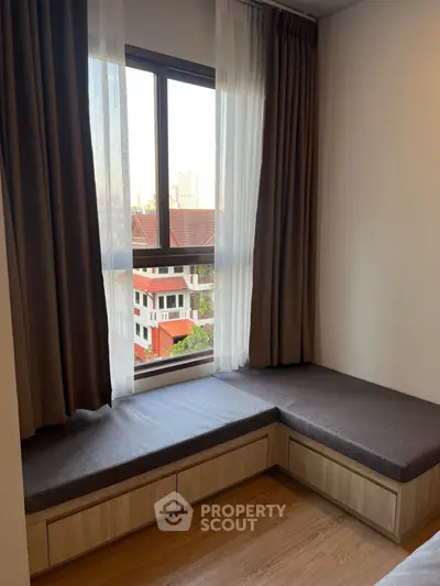 Cozy bedroom nook with window seating and city view