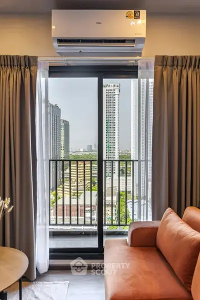 Modern living room with city view and air conditioning, featuring a cozy sofa and large window.