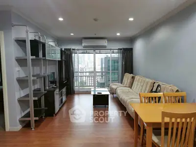 Spacious living room with modern furniture and city view balcony.