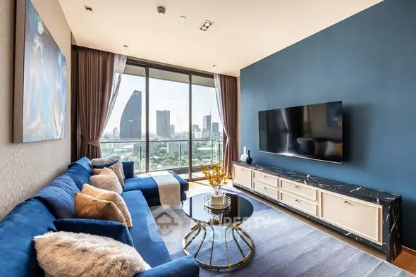 Luxurious living room with stunning city view, featuring elegant blue sofa and modern decor.