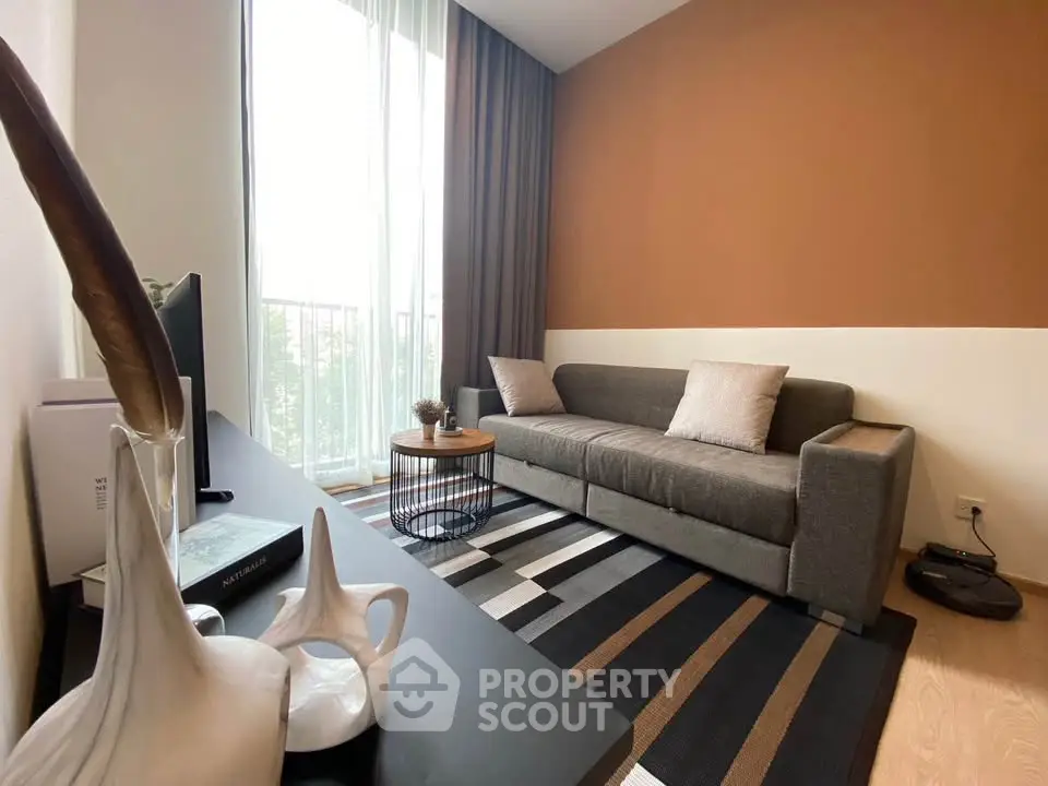 Stylish living room with modern decor and natural light, featuring a cozy sofa and elegant accents.