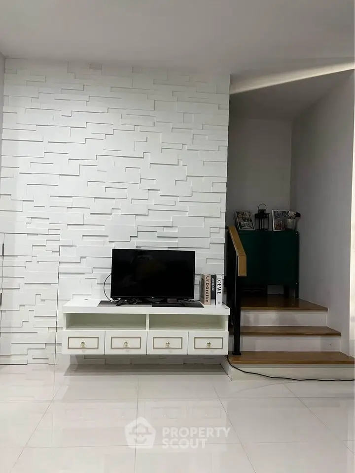 Modern living room with sleek white wall paneling and minimalist TV setup