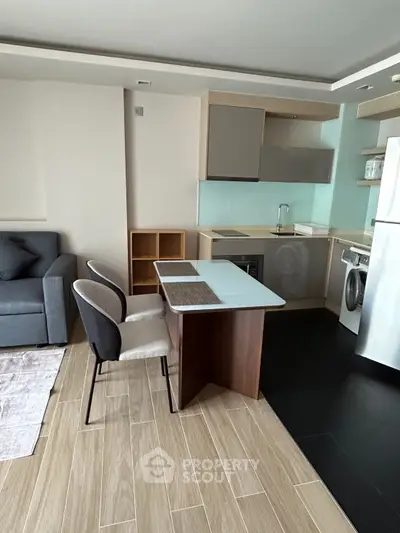 Modern open-layout kitchen with dining area and cozy living space in a stylish apartment.