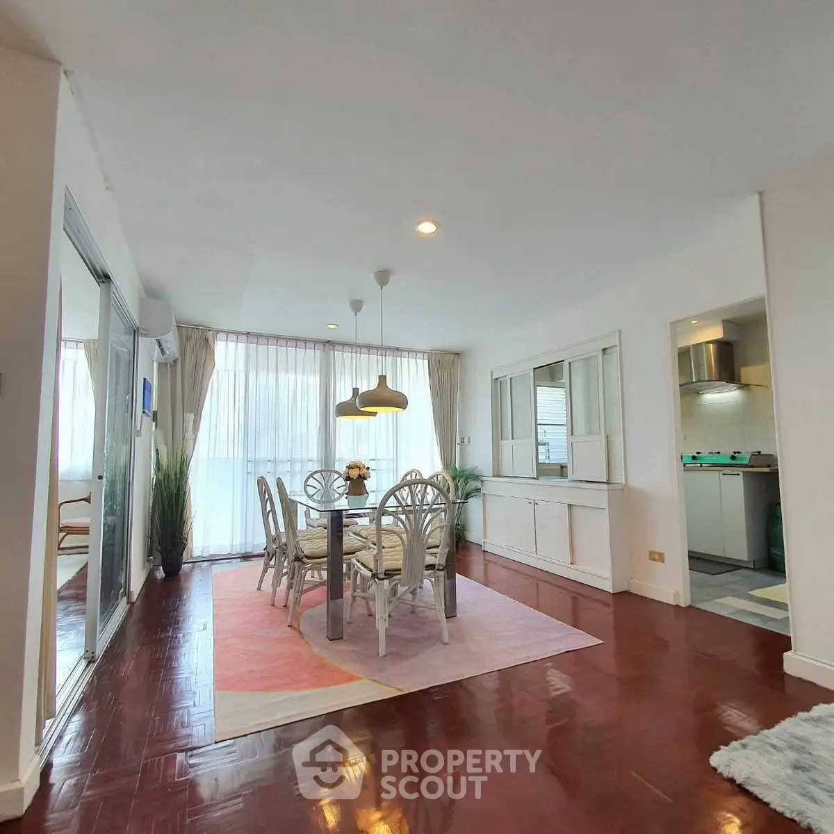 Spacious living room with dining area and natural light in modern apartment.