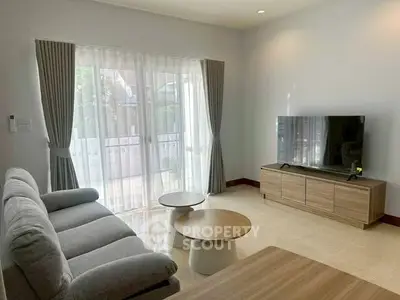 Spacious living room with modern furniture and large window for natural light.
