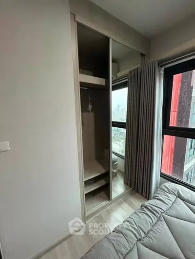 Modern bedroom with built-in wardrobe and city view window, perfect for urban living.
